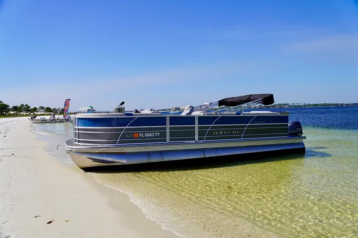 A pontoon boat beached on Shell Island sand on a full-day Shell Island pontoon rental from Panama City Beach, Florida