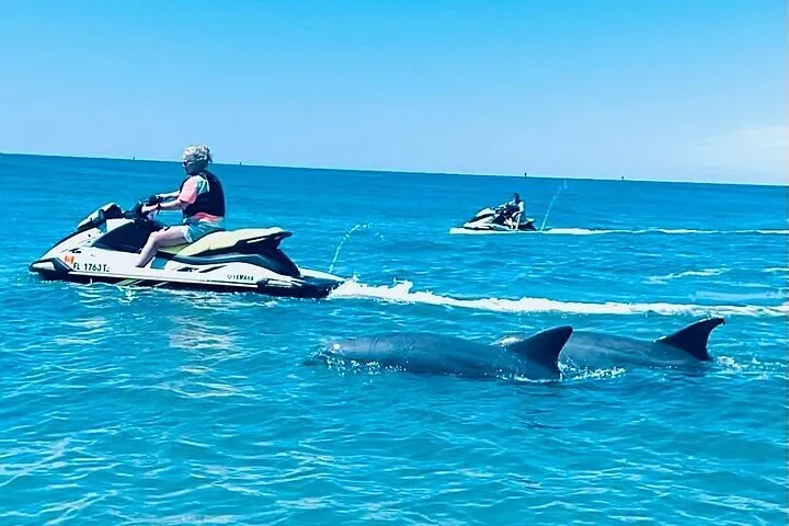 Riders on jet skis on emerald water on a Shell Island jet ski dolphin tour from Panama City Beach, Florida