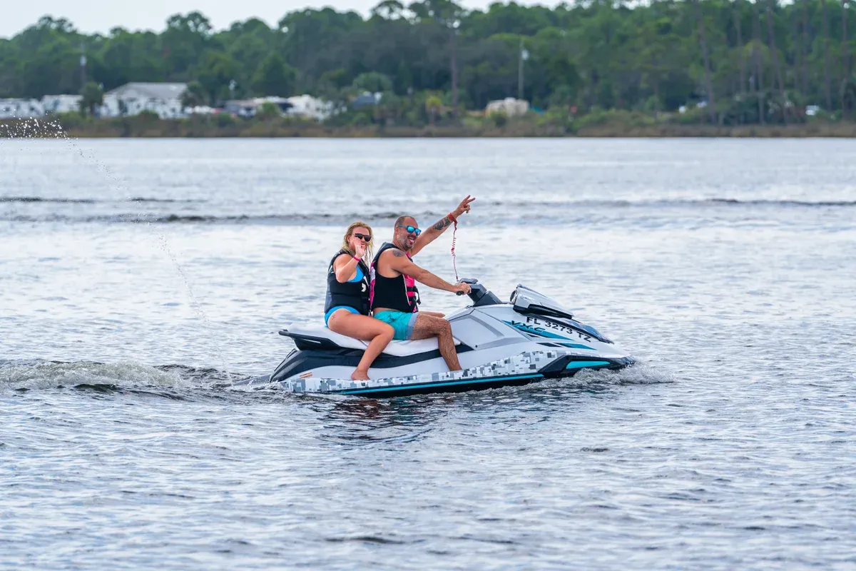 Two people sharing one jet ski in Panama City Beach, the way two riders share a ski on a jet ski dolphin tour in Panama City Beach, Florida